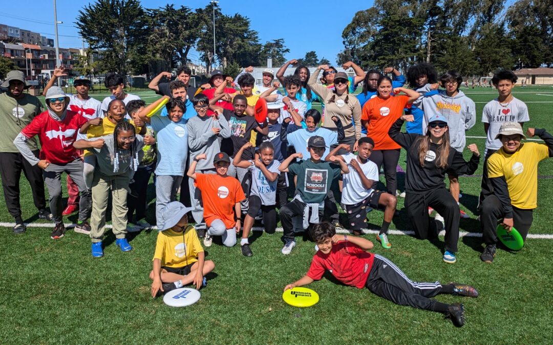 A group of Ultimate Impact participants and coaches show off their muscles